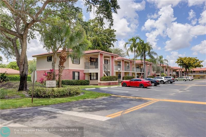 9649 Northwest 4th Street, Unit 5E Coral Springs, FL 33071 - Photo 17 of 30 a front view of a house with a garden and trees