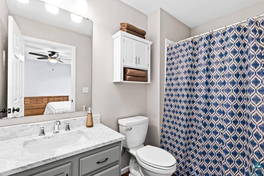 2020 East 11th Street Superior, WI 54880 - Photo 14 of 30 Ensuite bathroom featuring vanity, a shower with shower curtain, and a ceiling fan