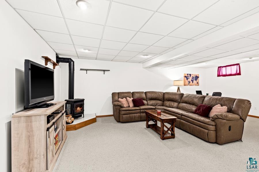 2020 East 11th Street Superior, WI 54880 - Photo 19 of 30 Living room with a drop ceiling, light colored carpet, and a wood stove