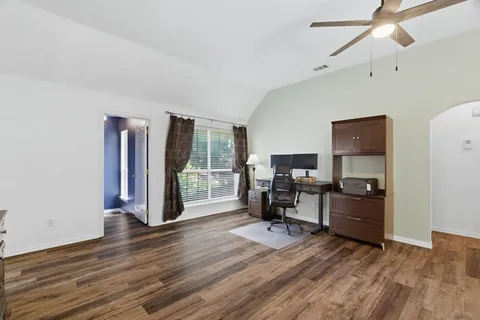 a view of a workspace with furniture and a window