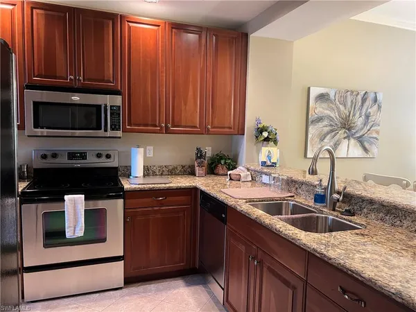 a kitchen with stainless steel appliances granite countertop a sink stove and microwave