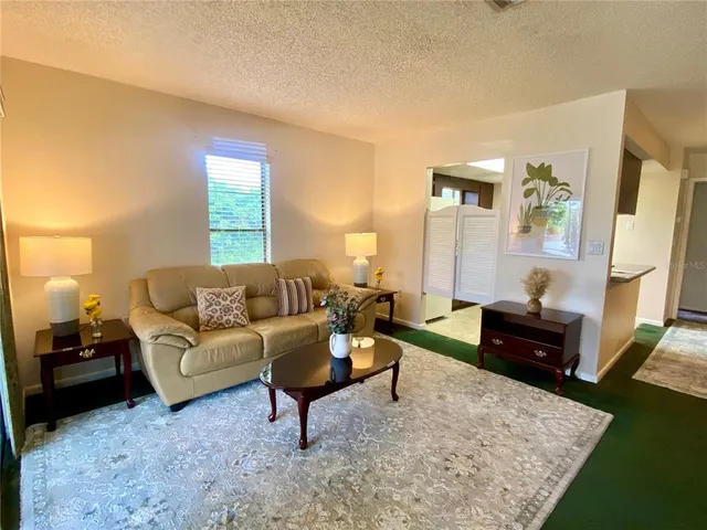 a living room with furniture and a chandelier