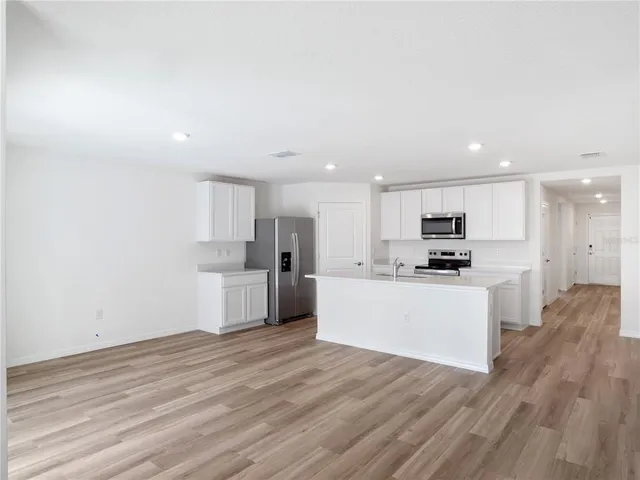 a view of kitchen with wooden floor and electronic appliances