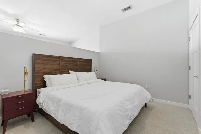 a large bed sitting in a bedroom next to a lamp