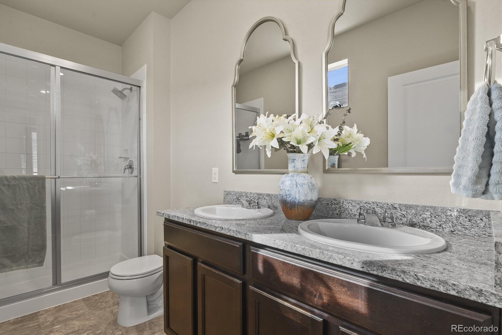 1078 Oak Circle Denver, CO 80215 - Photo 16 of 29 a bathroom with a granite countertop sink a toilet and a mirror