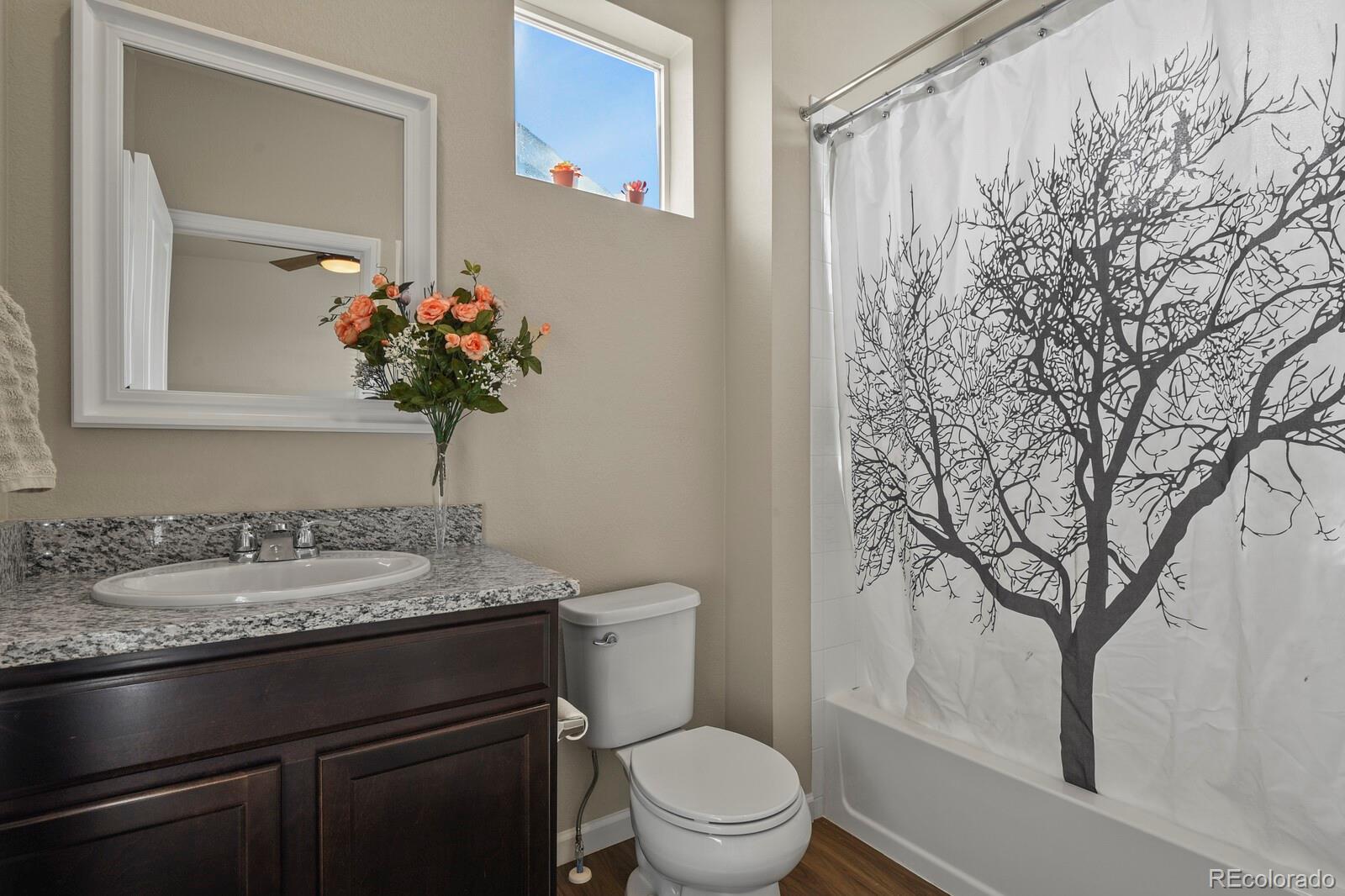 1078 Oak Circle Denver, CO 80215 - Photo 19 of 29 a bathroom with a granite countertop sink a toilet and a mirror