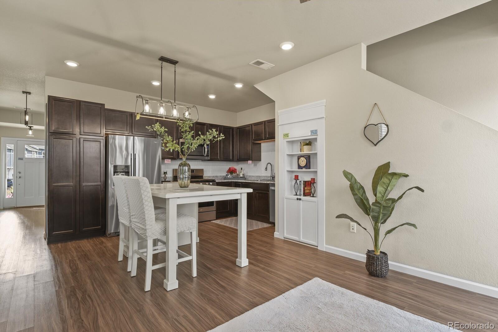 1078 Oak Circle Denver, CO 80215 - Photo 9 of 29 a kitchen with stainless steel appliances granite countertop a refrigerator a stove a sink and white cabinets with wooden floor