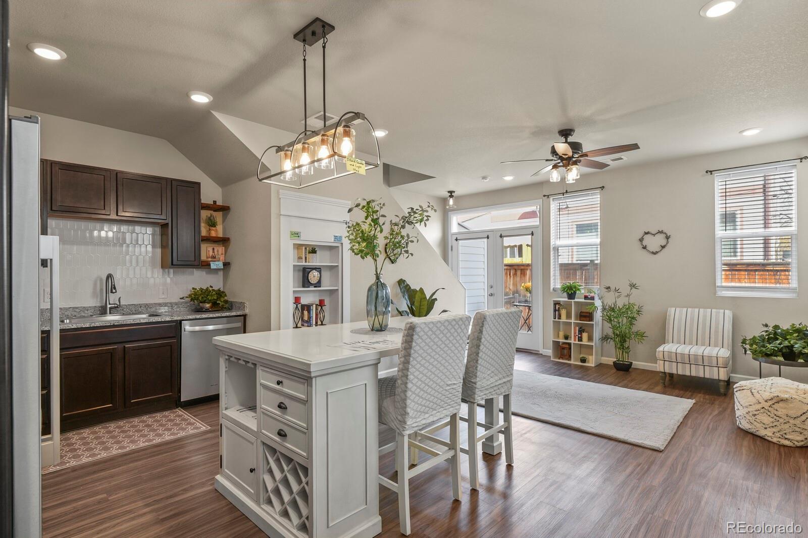 1078 Oak Circle Denver, CO 80215 - Photo 10 of 29 a large kitchen with stainless steel appliances granite countertop a stove oven a dining table and chairs with wooden floor