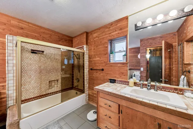 a bathroom with a granite countertop sink mirror bathtub and shower
