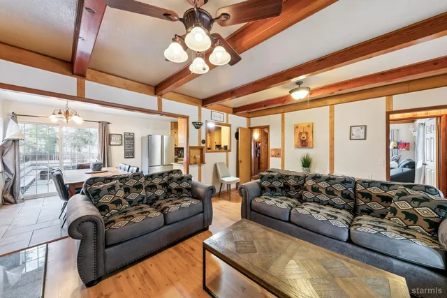 a living room with furniture ceiling fan and a large window