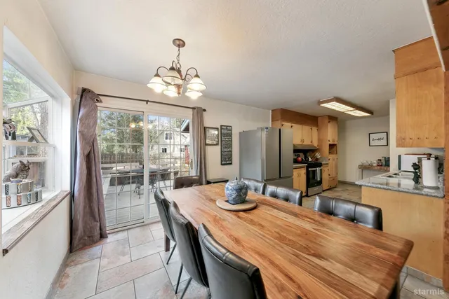 a dining room with wooden floor a chandelier a wooden table and chairs