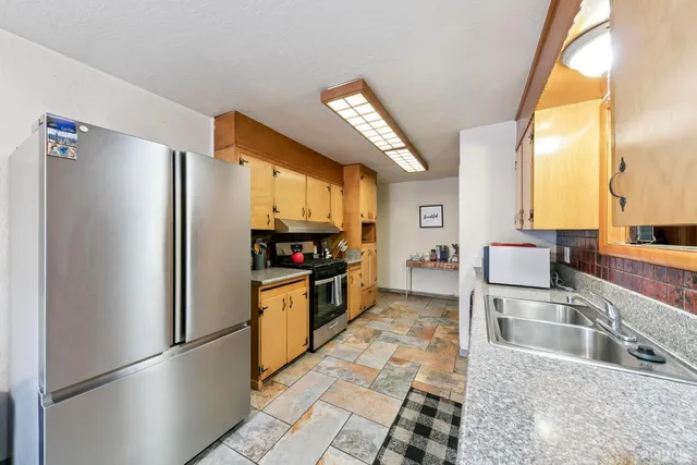 a kitchen with granite countertop a refrigerator and a sink