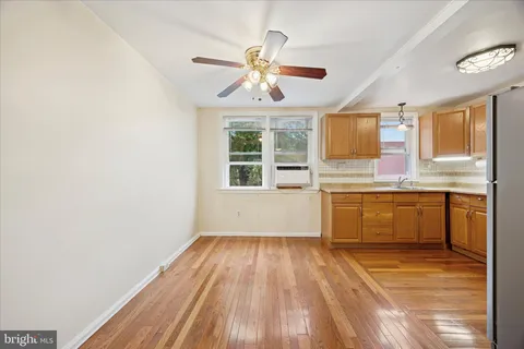 a view of a kitchen with wooden floor and stainless steel appliances