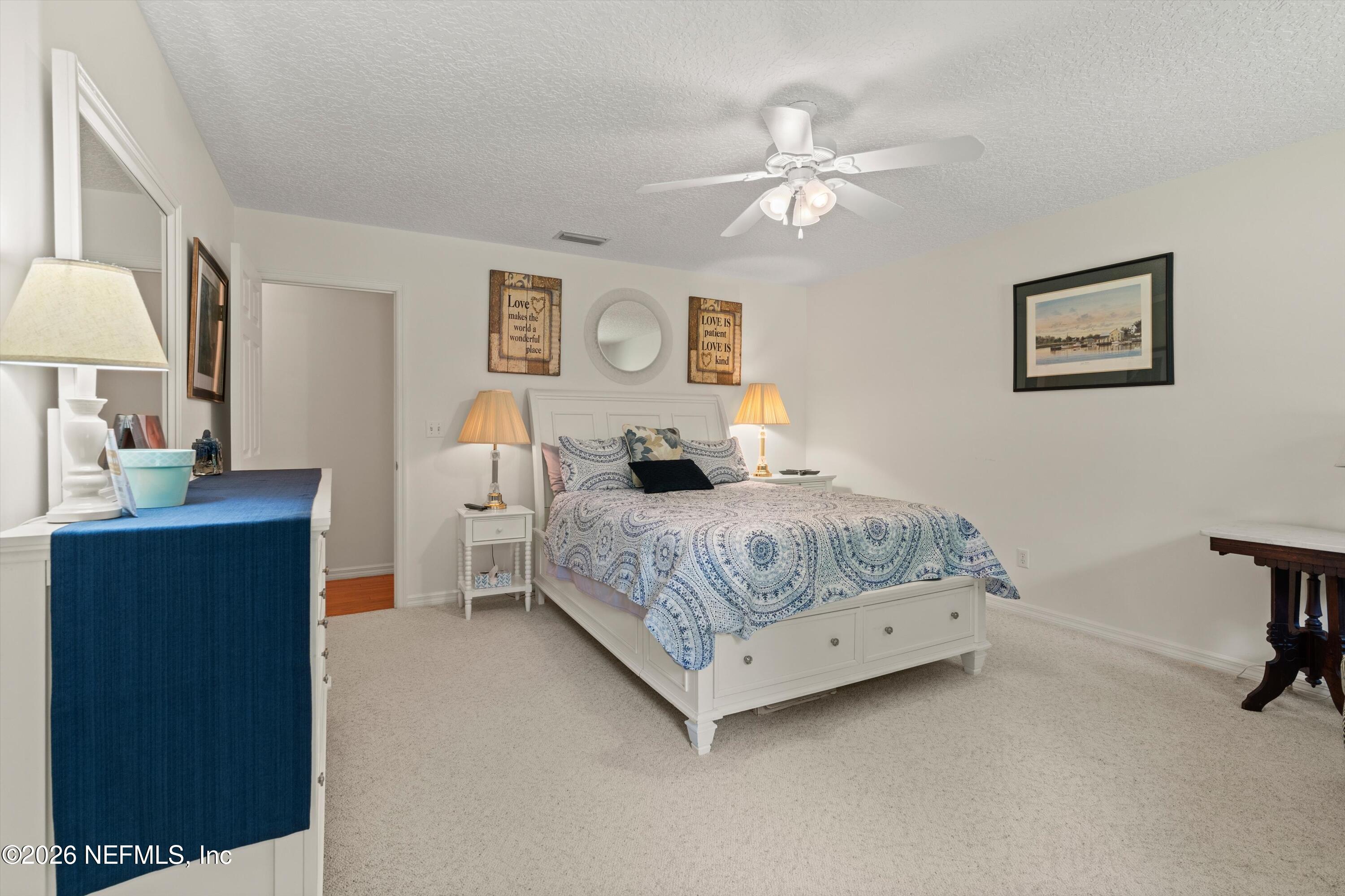 5566 Don Manuel Road Elkton, FL 32033 - Photo 26 of 47 a bedroom with a large bed and a chandelier