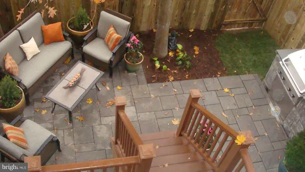 a balcony with chairs and a potted plant