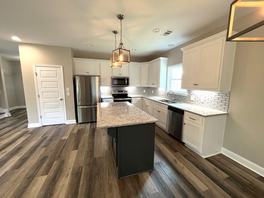4024 Valley Road Columbus, GA 31907 - Photo 16 of 35 a kitchen with stainless steel appliances granite countertop a refrigerator a sink dishwasher a stove and white countertops with wooden floor