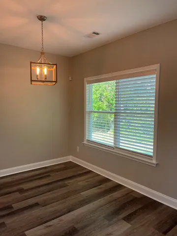 a view of a room with wooden floor and windows