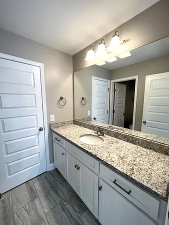 a bathroom with a granite countertop sink and a mirror