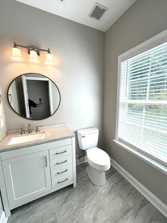 a bathroom with a toilet sink and mirror