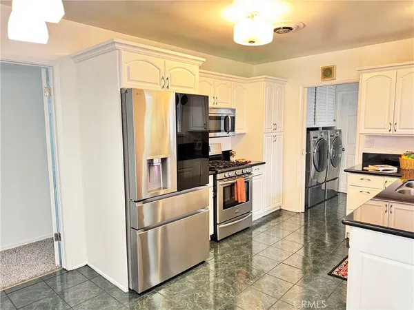 a kitchen with stainless steel appliances a refrigerator stove and microwave