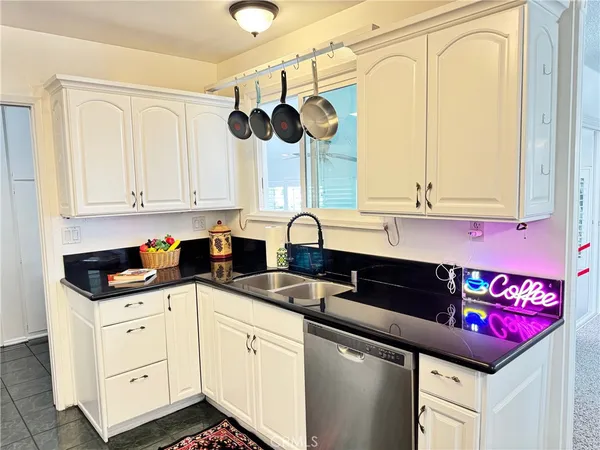 a kitchen with a sink dishwasher and white cabinets