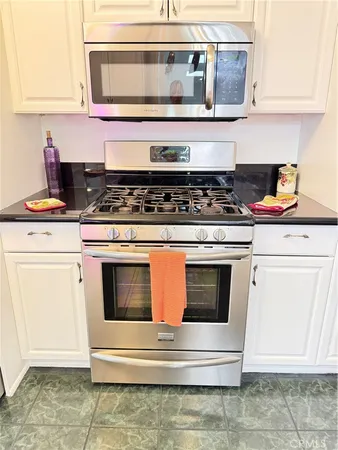 a stove top oven sitting inside of a kitchen and granite counter tops