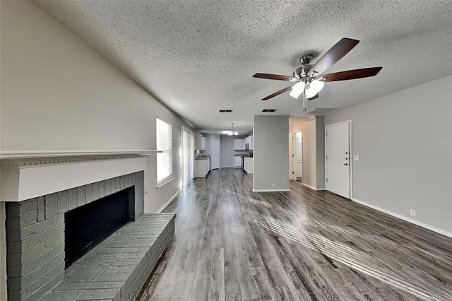 a view of a livingroom with wooden floor and a ceiling fan