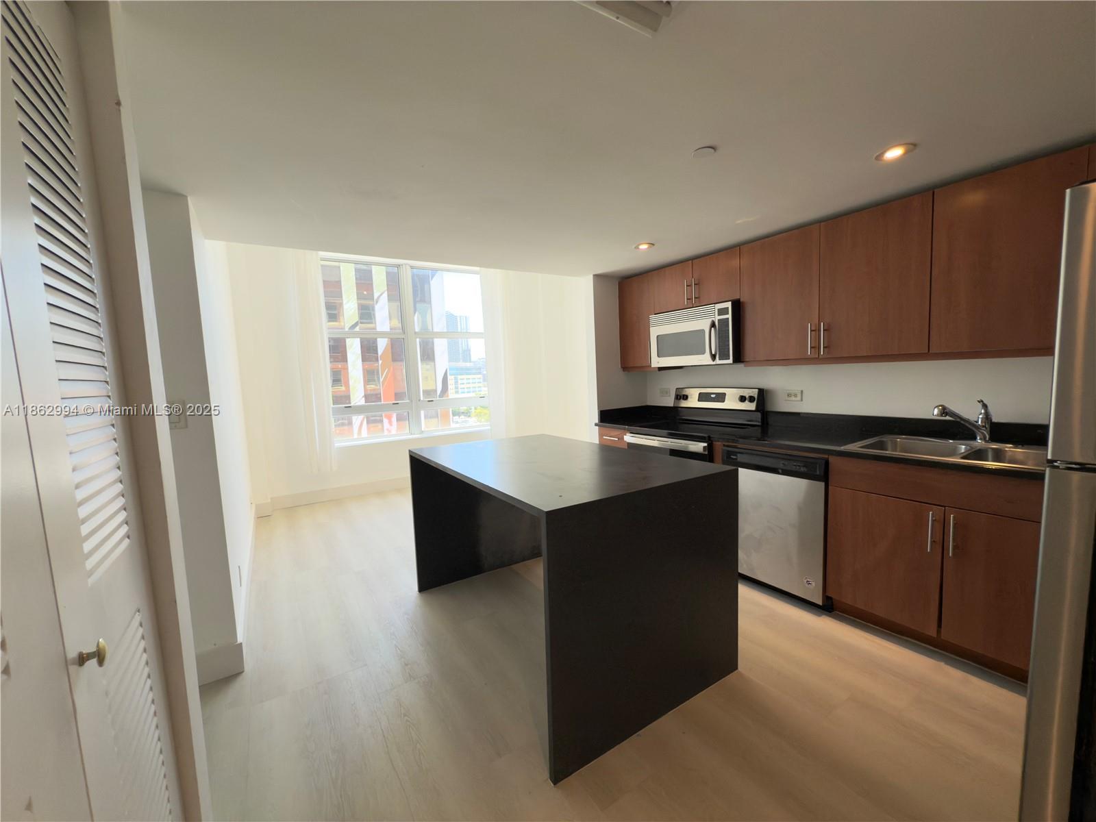 a kitchen with granite countertop a stove top oven a sink dishwasher and a microwave oven on the blue kitchen countertops