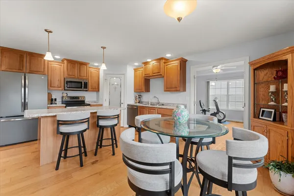 a kitchen with a dining table chairs and a refrigerator
