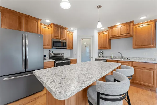 a kitchen with stainless steel appliances granite countertop a sink refrigerator and microwave