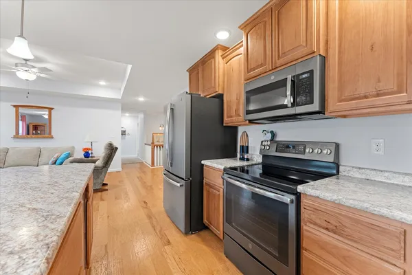 a kitchen with granite countertop a refrigerator stove and microwave