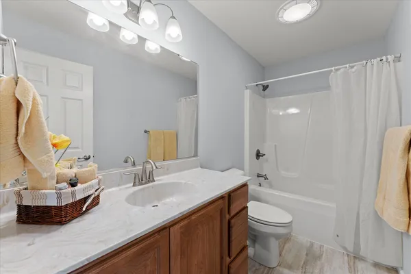 a bathroom with a granite countertop sink a toilet and shower