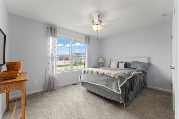a spacious bedroom with a bed and a window