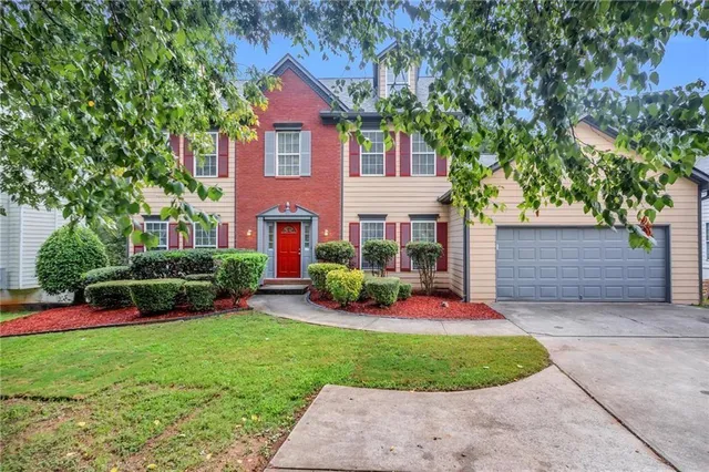 a view of a house with a yard and tree s
