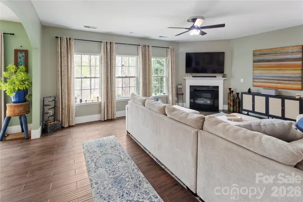 a living room with furniture a flat screen tv and a fireplace