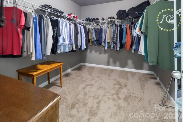 a view of walk in closet with clothes