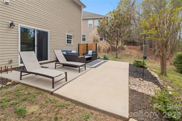a view of backyard of house with outdoor seating and trees