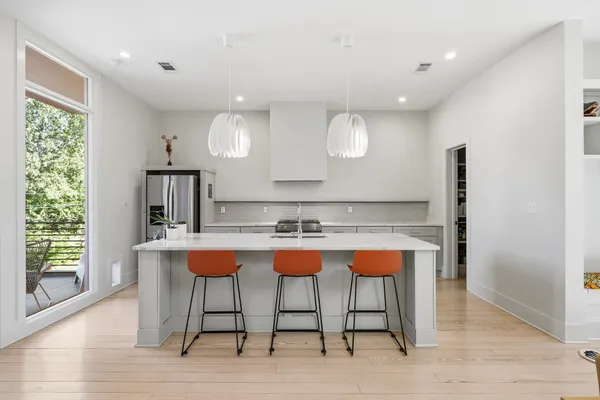a kitchen with stainless steel appliances granite countertop a table chairs sink and wooden floor