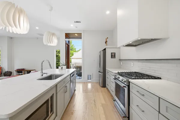 a kitchen with stainless steel appliances granite countertop a sink stove and cabinets
