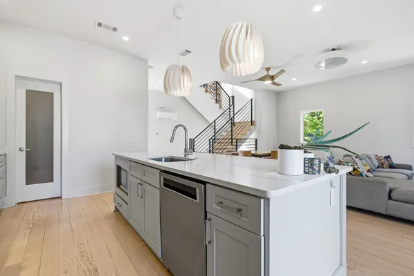 a kitchen with kitchen island a sink and a stove with wooden floor
