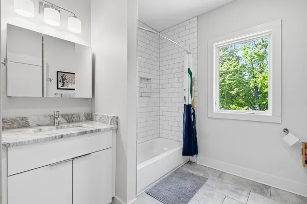a bathroom with a granite countertop sink and a mirror
