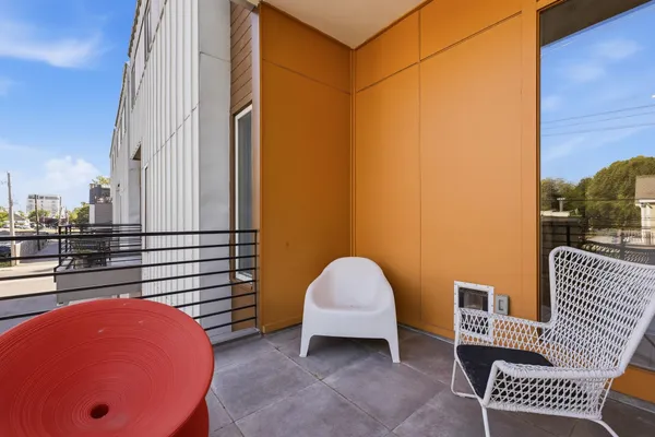 a view of a balcony with a chair and potted plants