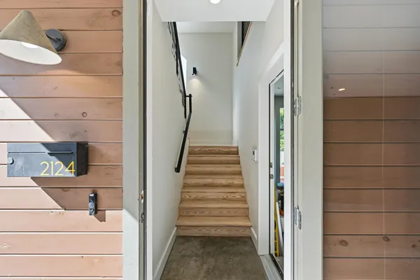 a view of a hallway with wooden floor and staircase