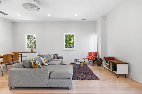 a living room with furniture and a wooden floor