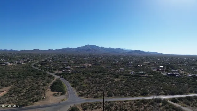 a view of a lush green field with mountains in the background