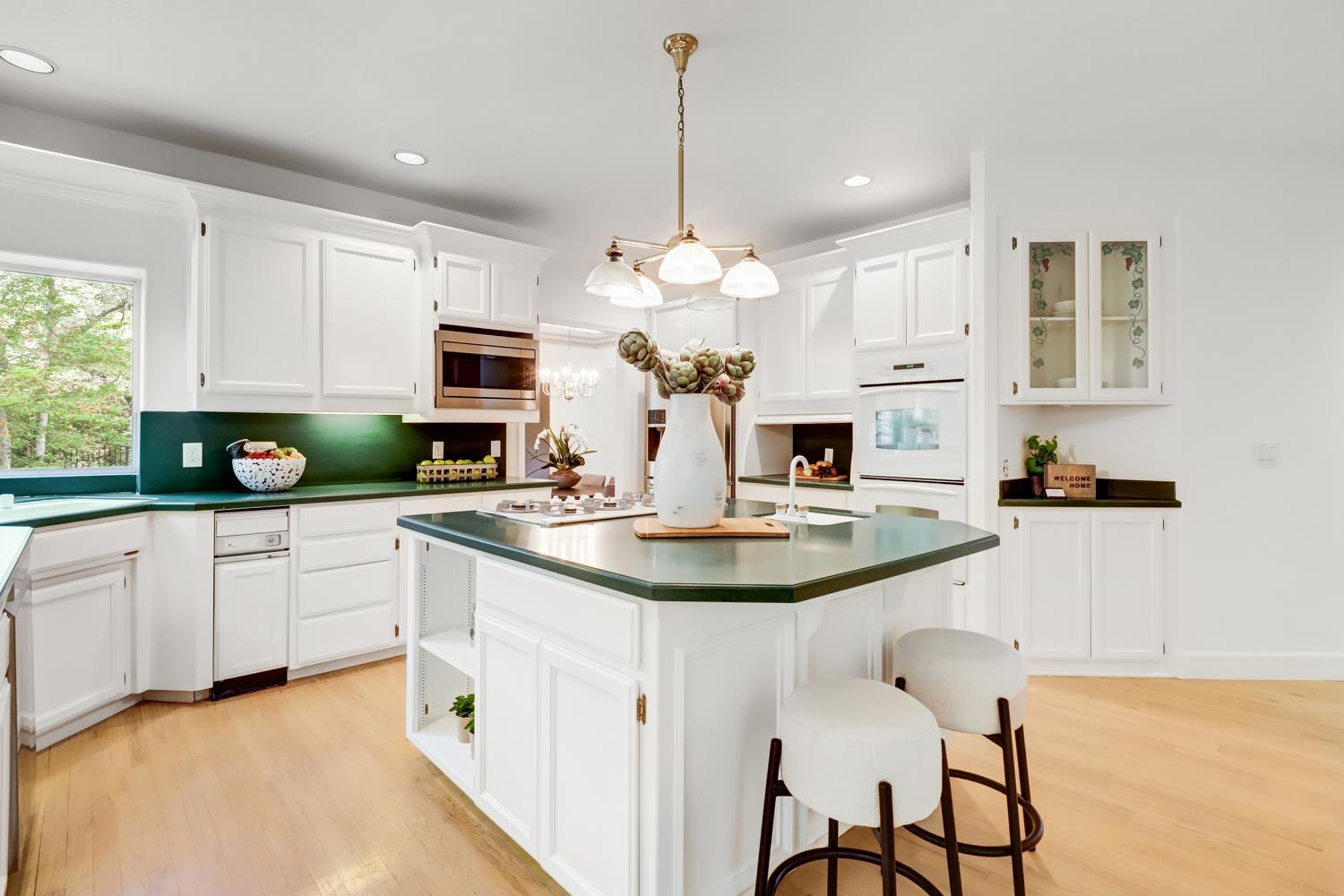 3058 Ridgeview Drive El Dorado Hills, CA 95762 - Photo 18 of 73 a kitchen with kitchen island granite countertop a sink a white cabinets and chairs with wooden floor