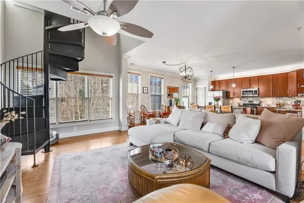 a living room with furniture a ceiling fan and a window