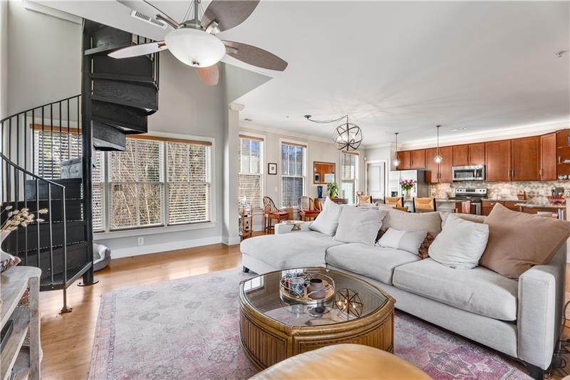 a living room with furniture a ceiling fan and a window