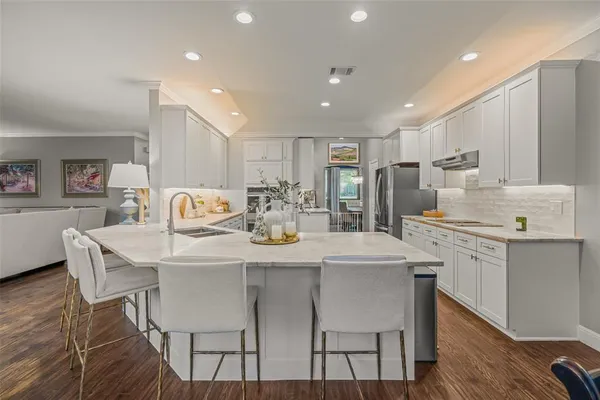 a kitchen with appliances cabinets and wooden floor