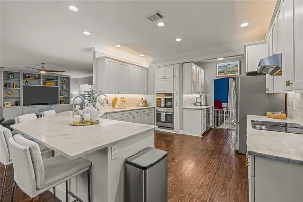 a kitchen with stainless steel appliances granite countertop a sink stove and refrigerator
